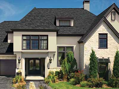 Front view of a beige, mid-class home with black GAF shingles on its roof
